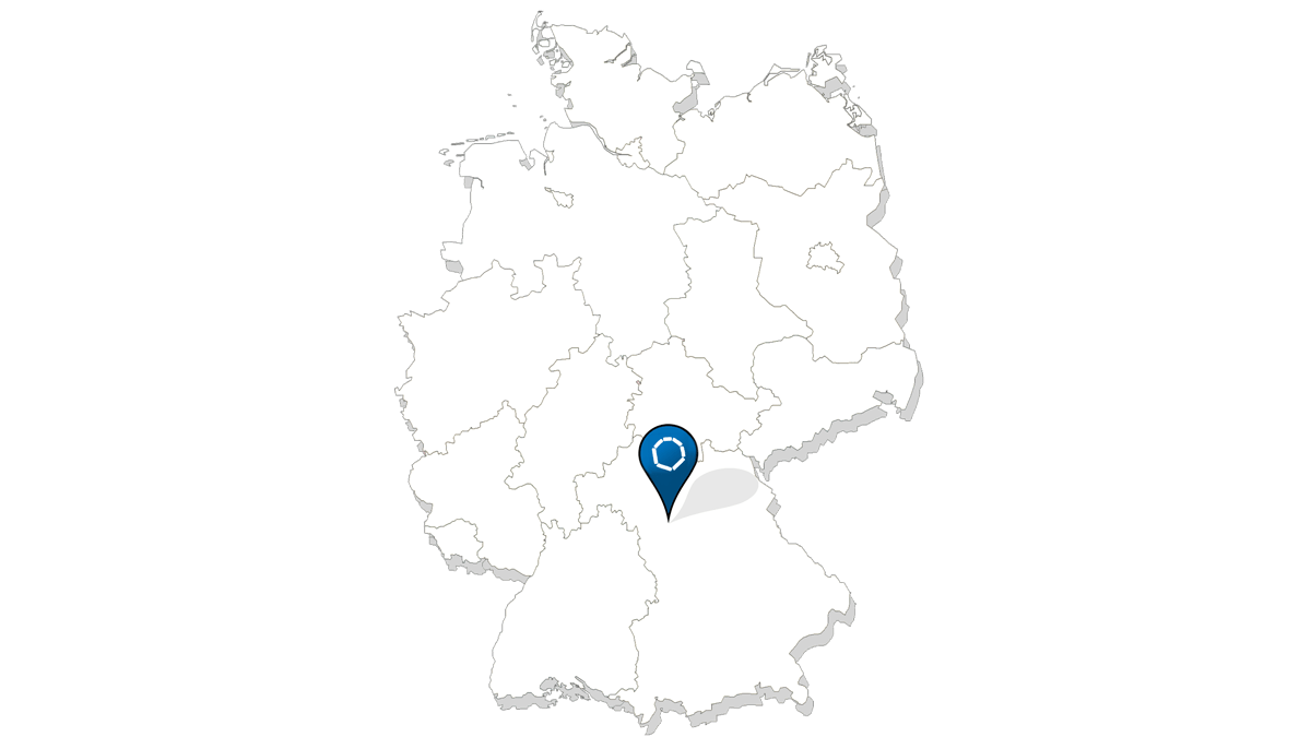 Eine stilisierte Karte von Deutschland, die die Bundesländer in einfachen Linien darstellt. In der Mitte, etwas südlich gelegen, befindet sich eine Markierung in Form eines blauen Standort-Pins mit einem weißen Symbol in der Mitte, das auf die Position eines spezifischen Ortes hinweist. Diese Markierung zeigt wahrscheinlich die Lage des Aischtaler Bauzentrums an.