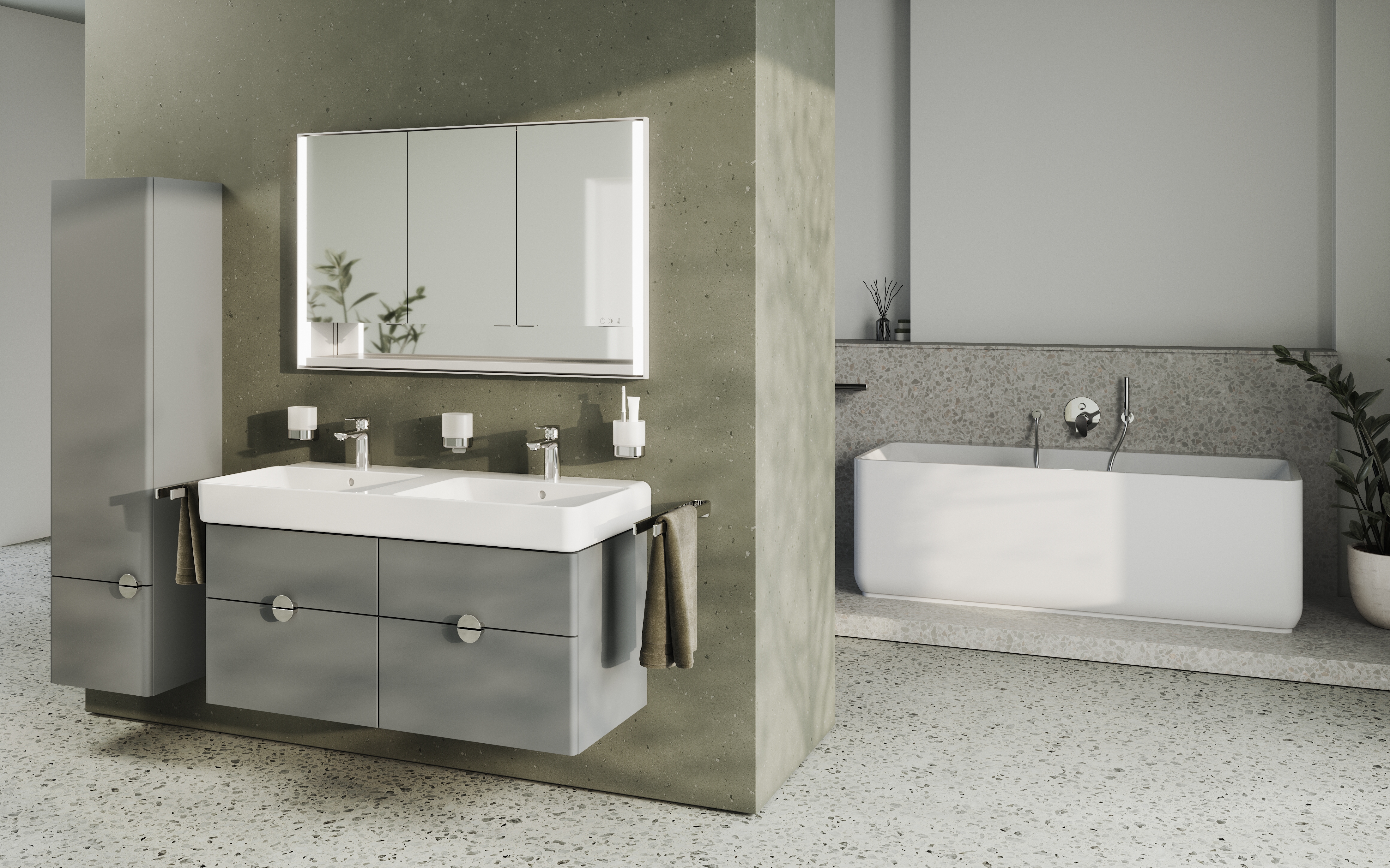 Ein modernes Badezimmer mit einem Doppelwaschbecken und einem großen Spiegel, der über der Waschtischanlage hängt. Auf der rechten Seite des Raumes befindet sich eine freistehende Badewanne. Das Design ist in neutralen Farben gehalten, mit Terrazzo-Boden und Akzenten in Chrom.